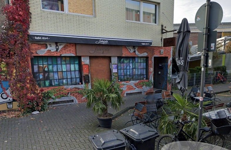Straßenansicht mit Graffiti-Kunst und Sitzgelegenheiten in Liebefeld.