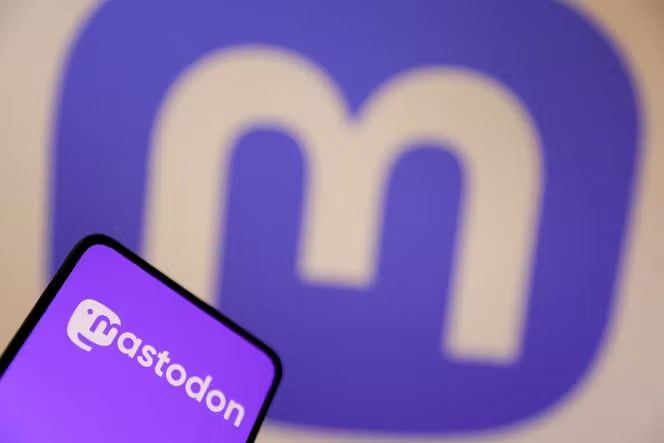 Dirk Bachhausen mit Mastodon Logo vor großem M im Hintergrund.