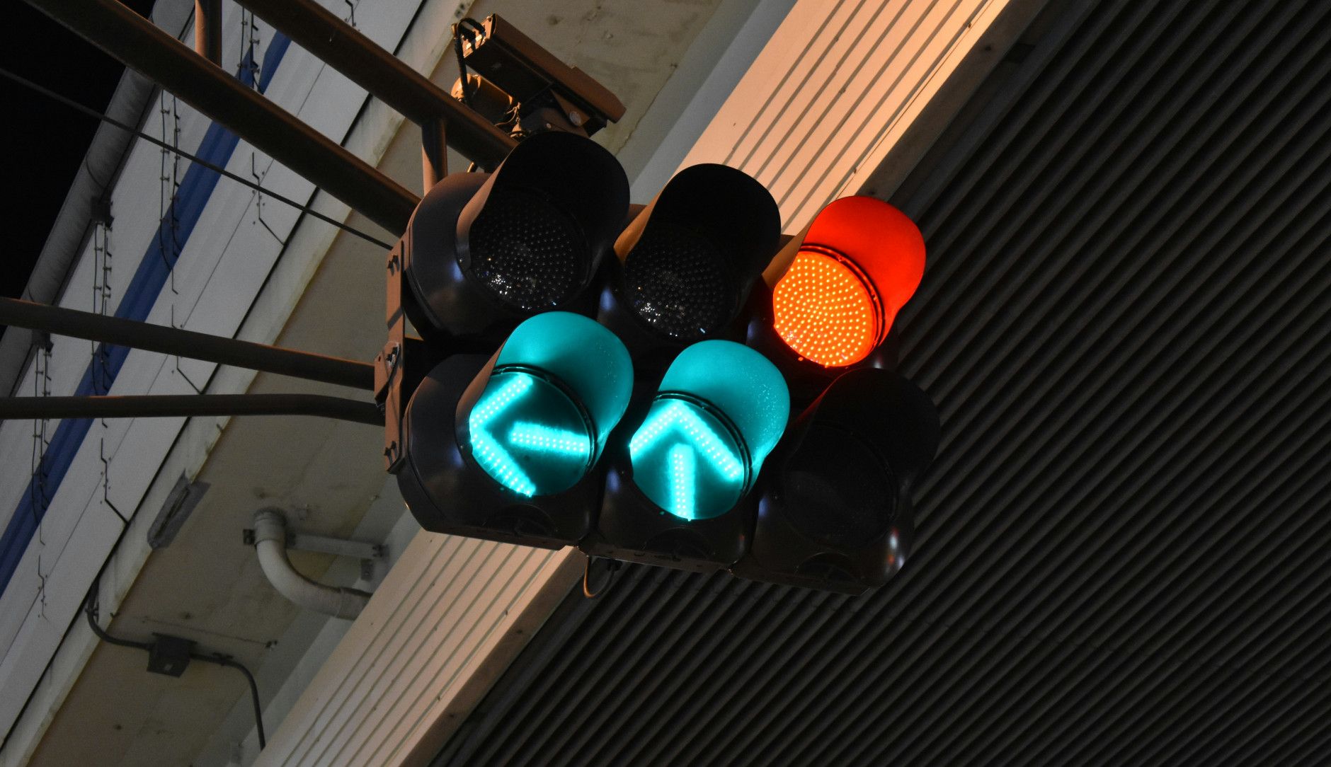 Ampel mit grünen und roten Lichtsignalen in einer Industrieumgebung.