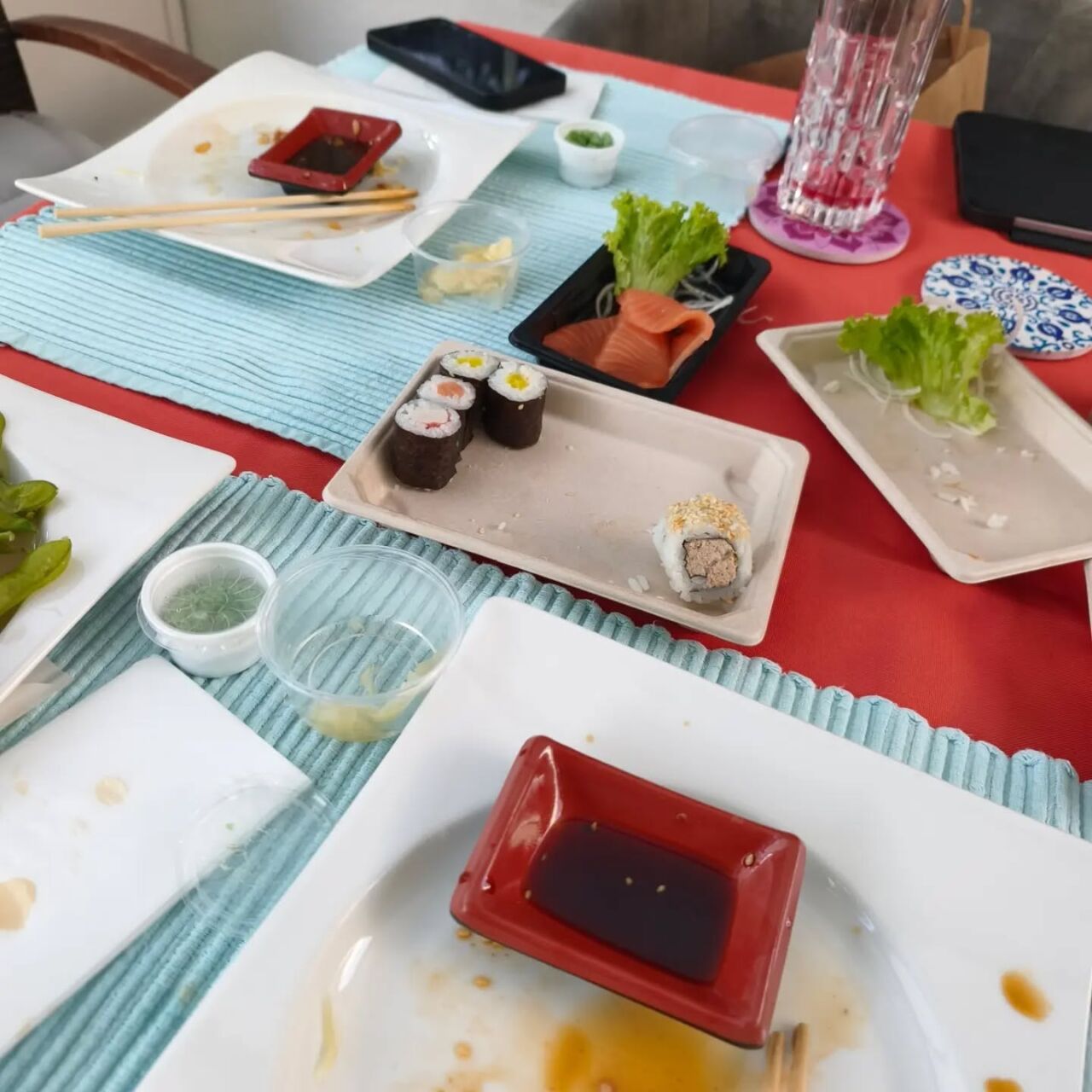 Frisches Sushi mit Sojasauce und Wasabi auf einem Tisch.