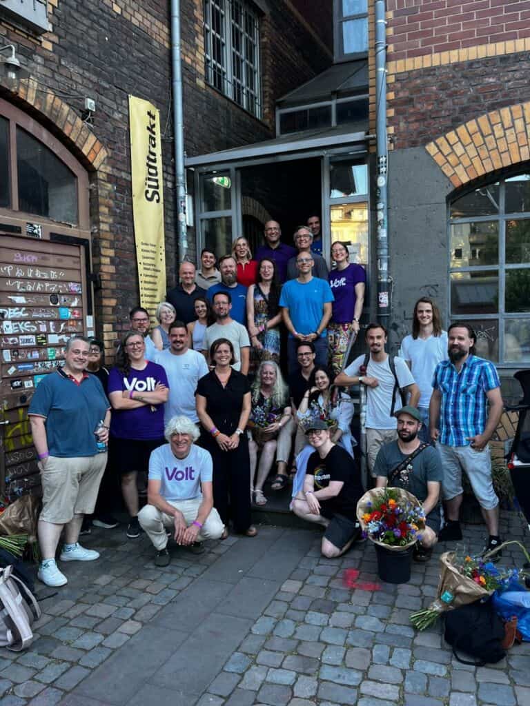 Gruppe von Menschen vor einem Gebäude bei einer Veranstaltung in Köln.
