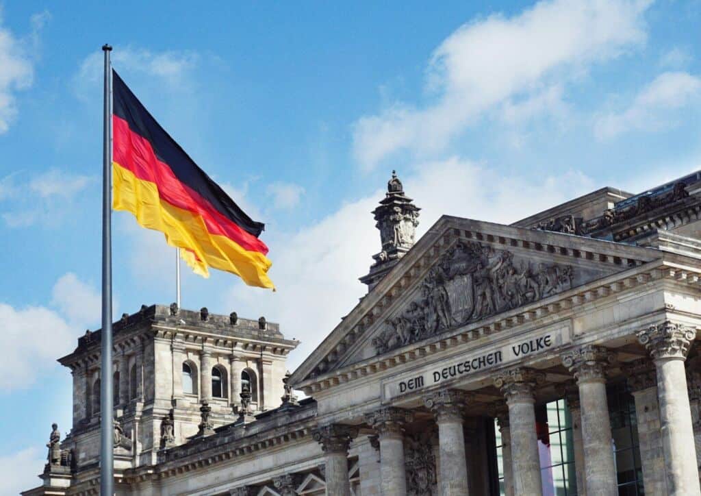 Deutscher Reichstag mit Flagge und Inschrift 'Dem Deutschen Volke'.