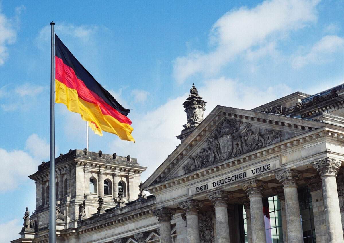 Deutscher Reichstag mit Flagge und Inschrift 'Dem Deutschen Volke'.