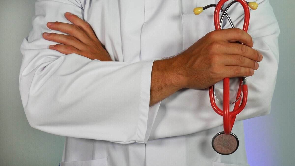 Arzt hält Stethoskop, symbolisiert medizinische Versorgung und Gesundheit.