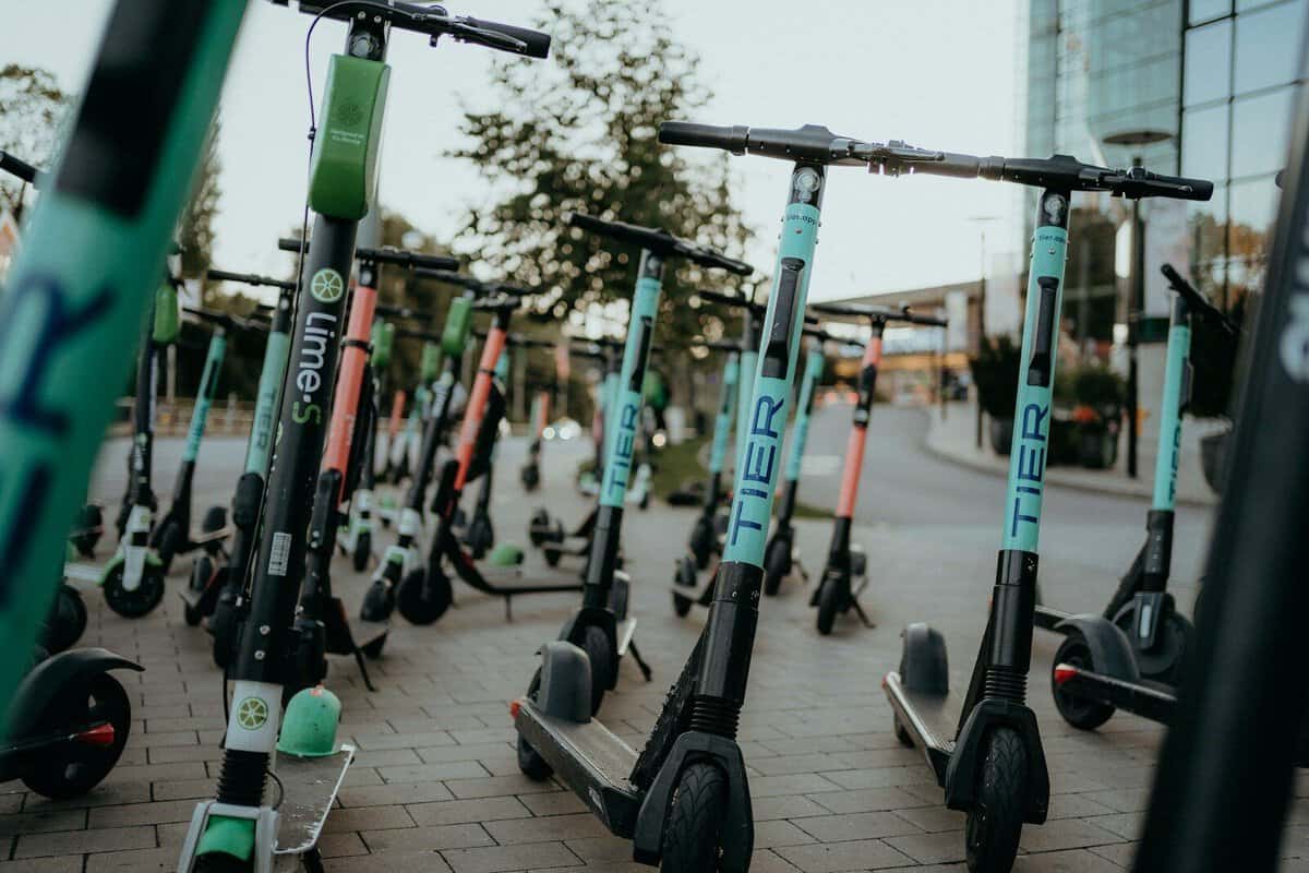 Mehrere E-Scooter auf einem Bürgersteig in der Stadt.