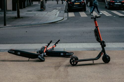 motorized scooters parked near road during daytime