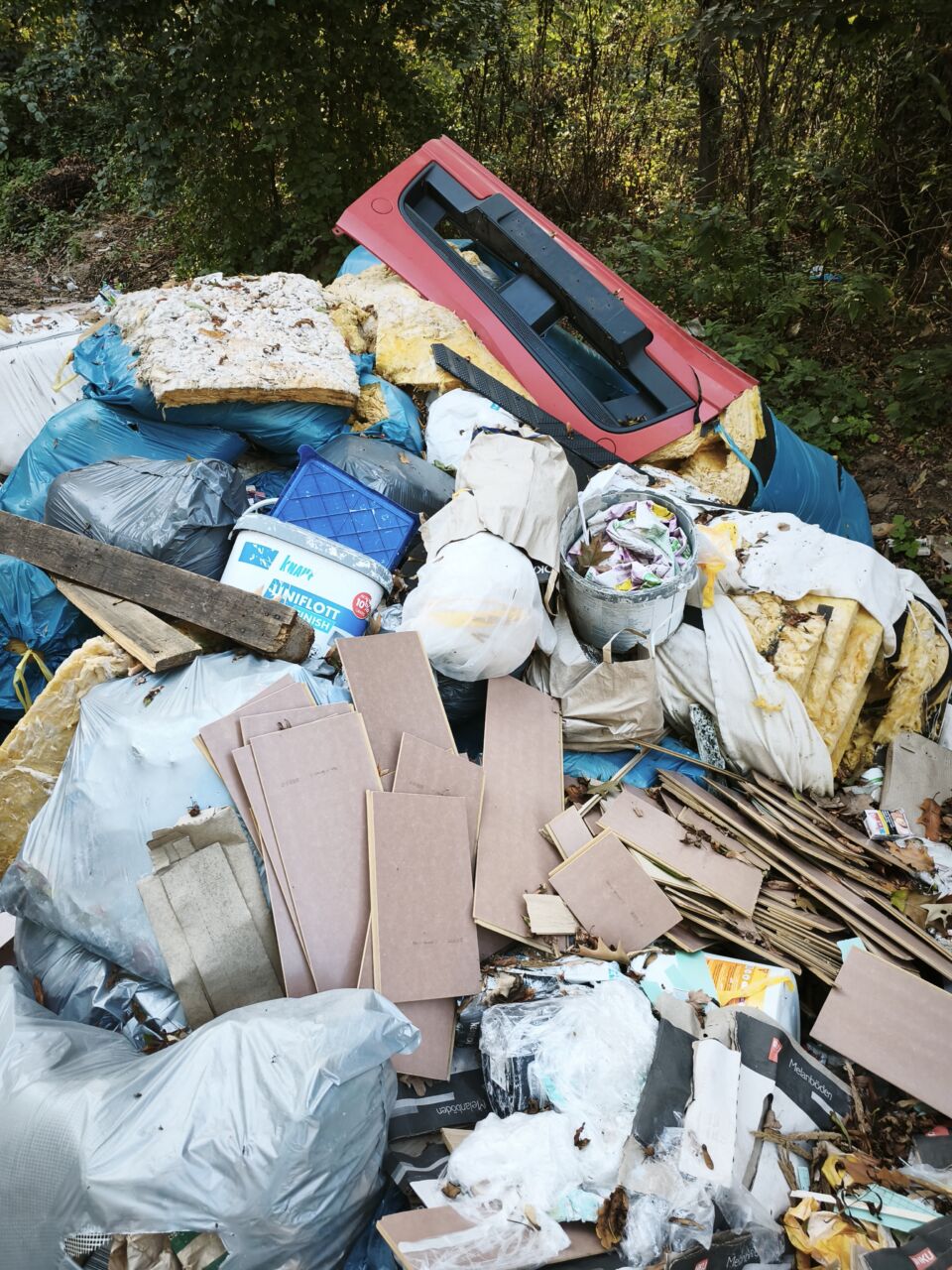 Müllhaufen mit Plastik, Papier und anderen Abfällen im Freien.