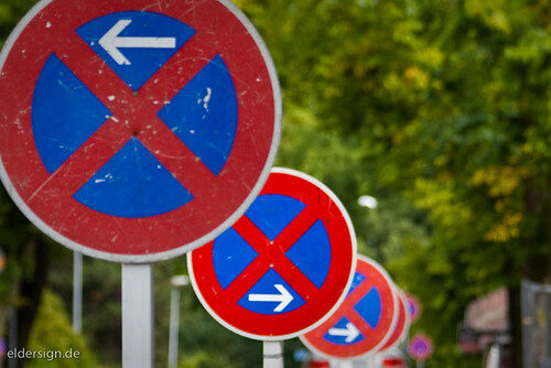 Mehrere Verkehrsschilder mit Parkverbot und Richtungsangaben.