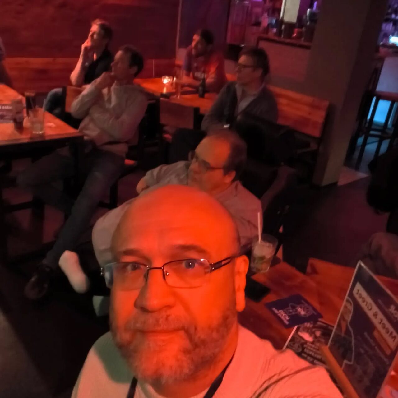 Gruppe von Menschen in einer Bar beim Abendessen, entspannte Atmosphäre.