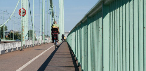 Radfahrer auf der Mülheimer Brücke mit Blick auf die Brückenpfeiler.