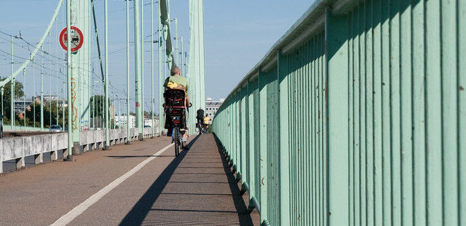 Radfahrer auf der Mülheimer Brücke mit Blick auf die Brückenpfeiler.
