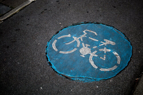 Blaue Fahrradmarkierung auf Asphalt im Kölner Norden.