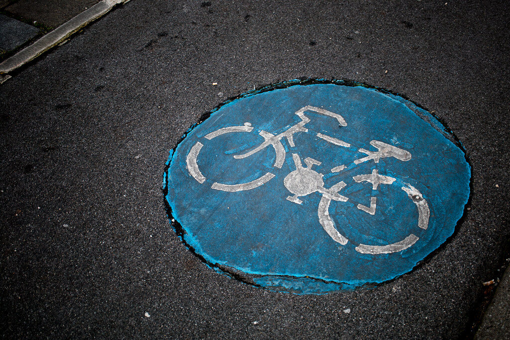 Blaue Fahrradmarkierung auf Asphalt im Kölner Norden.