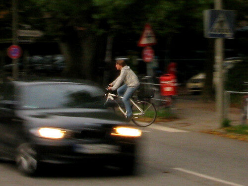 Radfahrer auf der Straße in Köln bei Verkehrssituation.