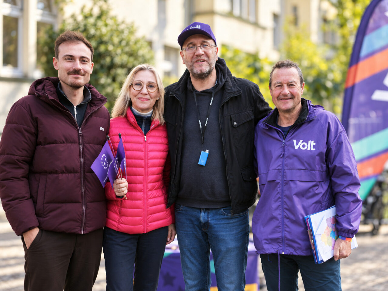 Vier Personen bei Wahlkampfveranstaltung in Heimersdorf, mit EU-Flagge und Wahlmaterial.