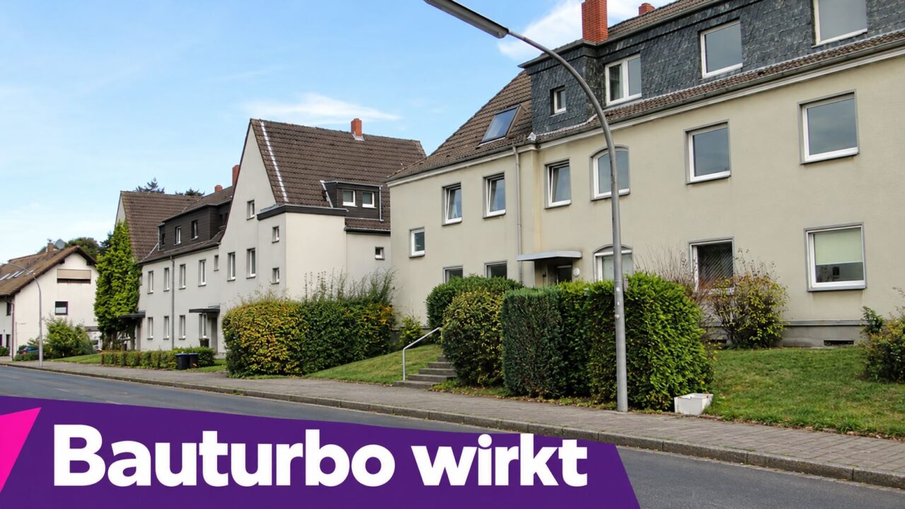 Mehrfamilienhäuser in Merkenich, Köln, mit gepflegtem Garten und Bushaltestelle.